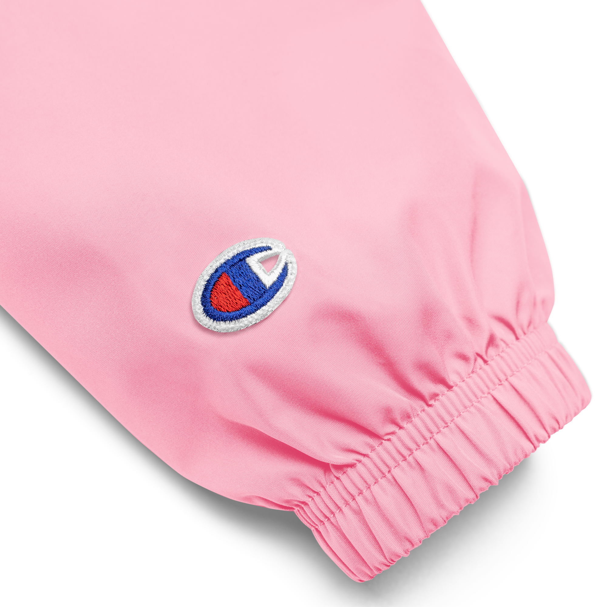 Close-up of the sleeve on pink Champion packable jacket with embroidered logo from Ukrainian Vibe Trizub Collection for women.