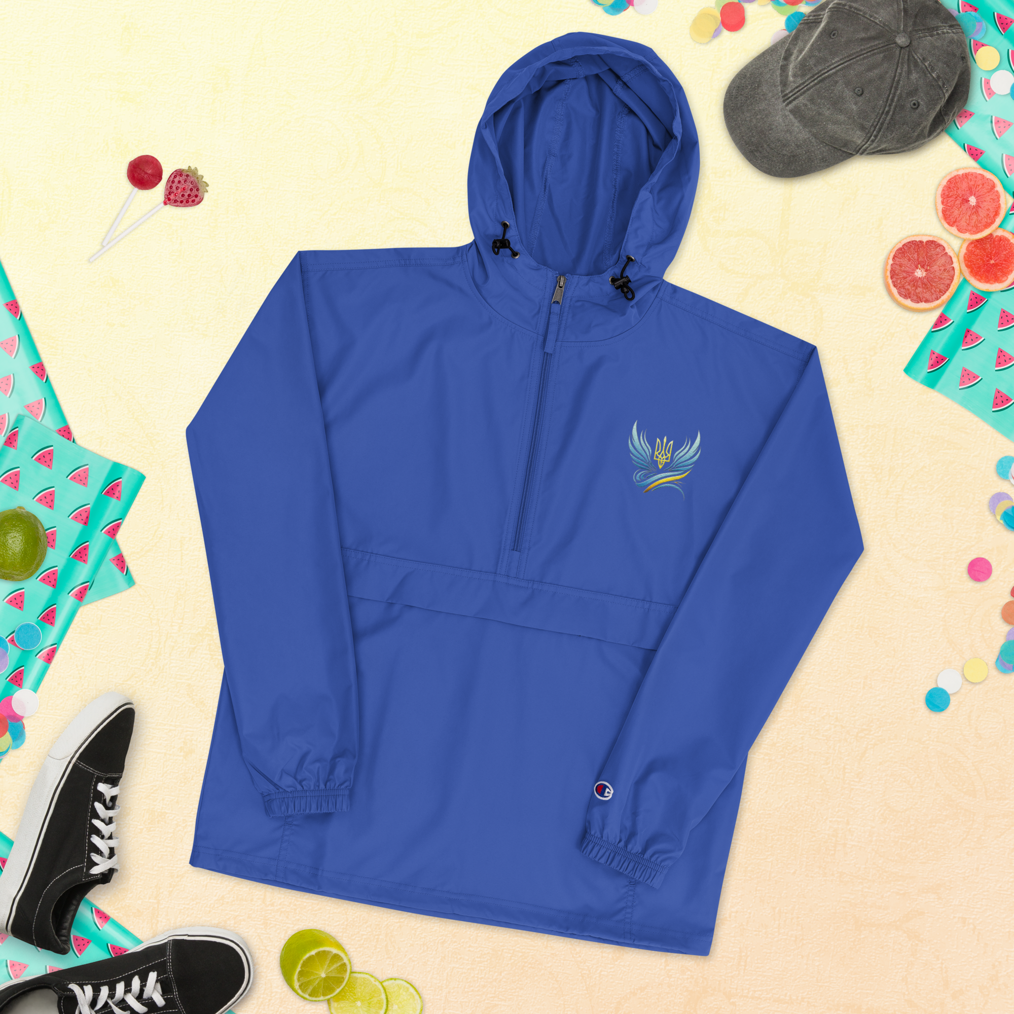 Blue embroidered Champion packable jacket from Ukrainian Vibe Trizub Collection for women, featuring a hood and kangaroo pocket.