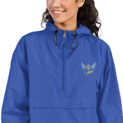 Woman wearing blue Ukrainian Vibe Trizub embroidered Champion packable jacket with hood and kangaroo pocket.