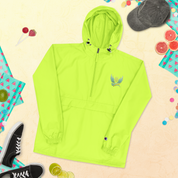 Ukrainian Vibe Trizub embroidered Champion packable jacket, bright green with hood, displayed alongside casual accessories.