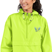 Woman wearing Ukrainian Vibe Trizub embroidered Champion packable jacket in lime green, featuring hood and kangaroo pocket.