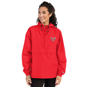 Woman wearing red Champion packable jacket from Ukrainian Vibe Trizub Collection with embroidered Trident logo.