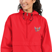 Woman wearing red embroidered Champion packable jacket from Ukrainian Vibe Trizub Collection, with Trizub logo, hood, kangaroo pocket.