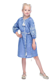 Girl wearing blue embroidered linen dress with woven belt and tassels, showcasing a traditional Ukrainian folk design.