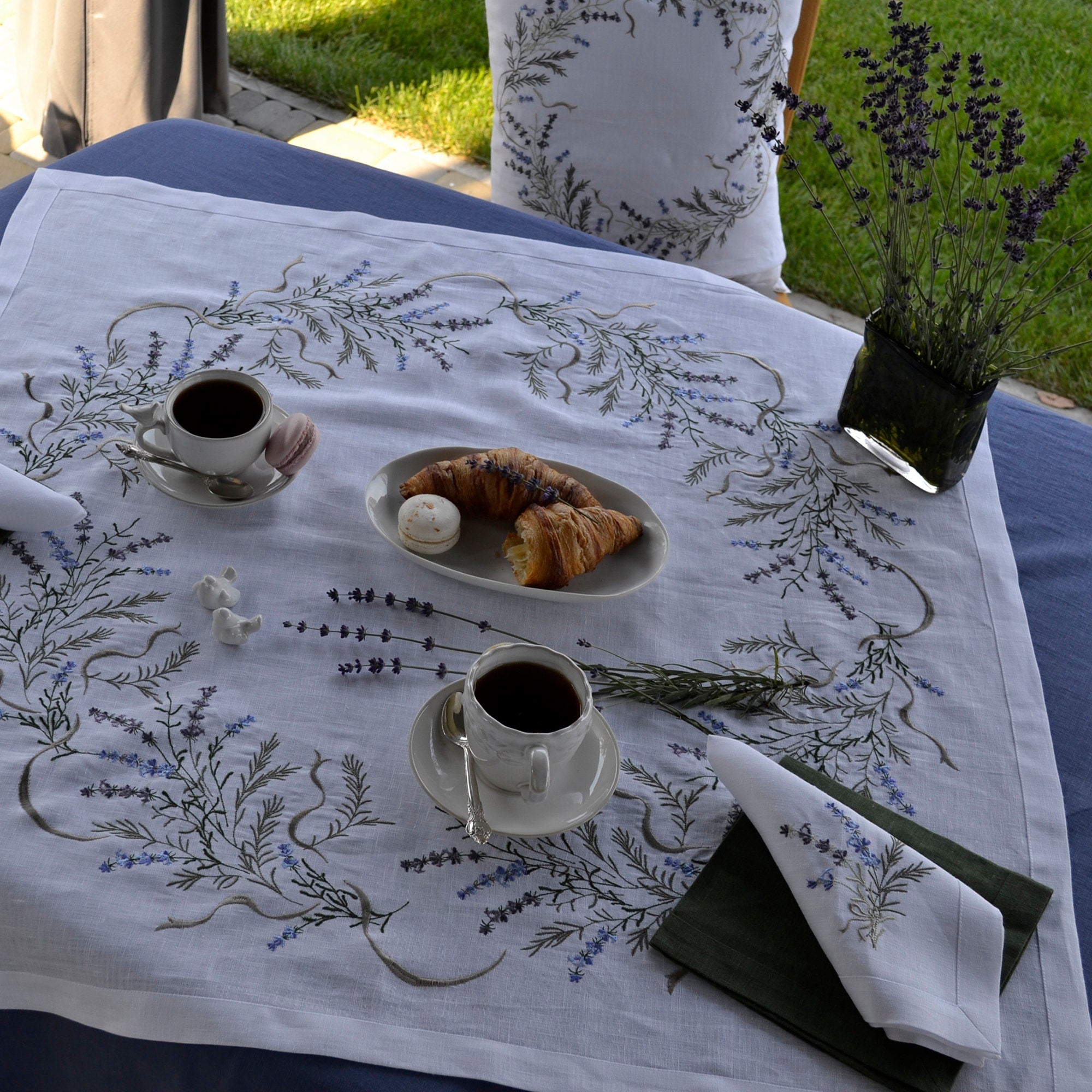 Embroidered linen tablecloth with lavender design, coffee cups, and pastries, showcasing Ukrainian folk artistry, perfect for special occasions.