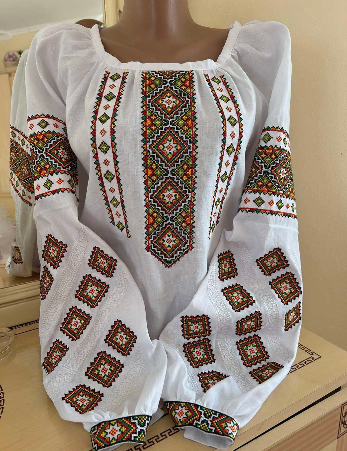 Traditional Ukrainian embroidered linen vyshyvanka blouse with authentic cross-stitch patterns, handmade by Carpathian artisans.
