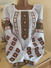 Traditional Ukrainian embroidered linen vyshyvanka blouse with authentic cross-stitch patterns, handmade by Carpathian artisans.