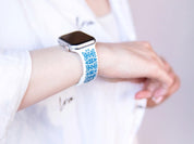 White and blue engraved Ukrainian embroidery Apple Watch band on wrist, showcasing intricate design and cultural heritage.