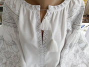 Women's ethnic white vyshyvanka blouse with traditional Ukrainian cross-stitch embroidery on homespun fabric.