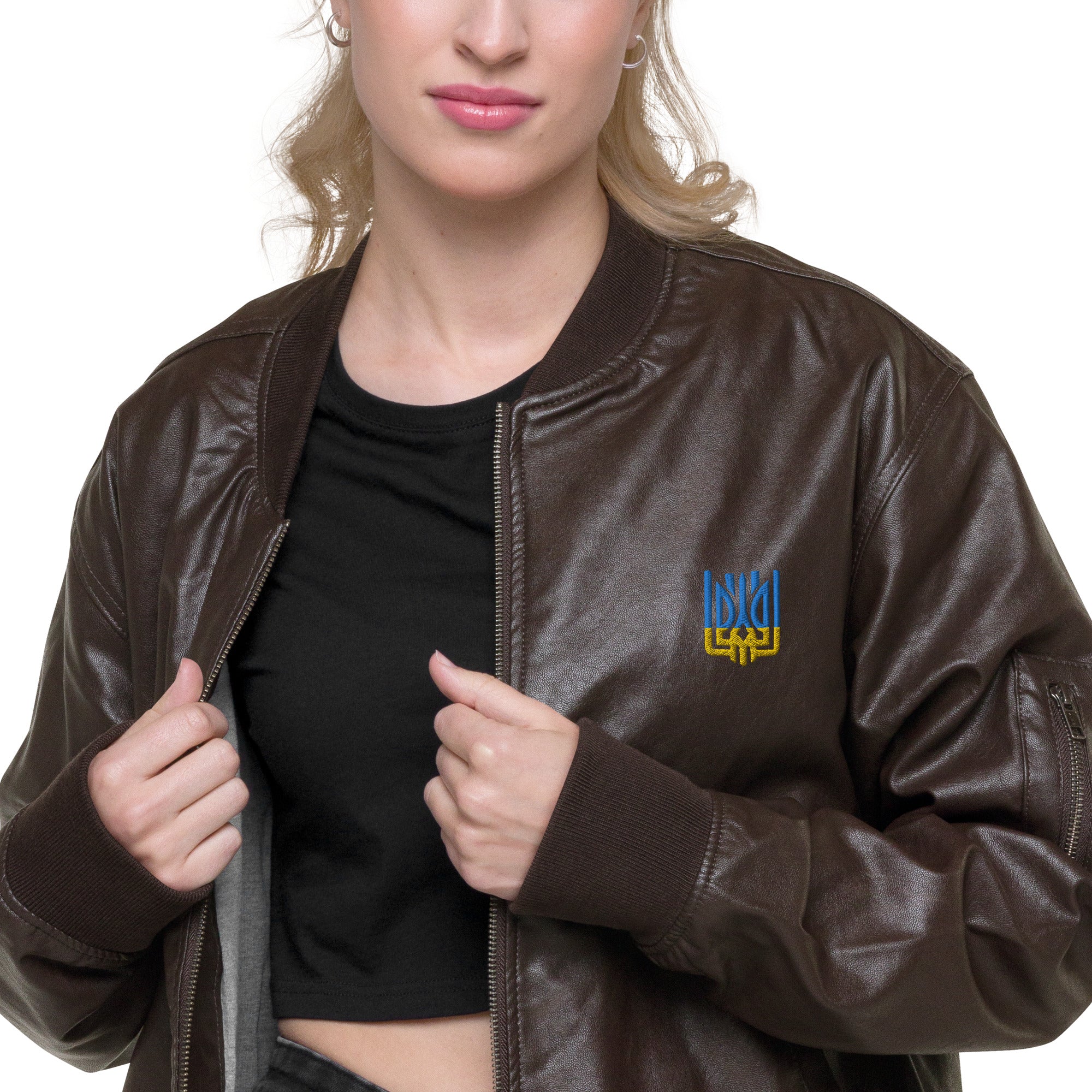 Woman wearing Ukrainian Vibe Tryzub Edition leather bomber jacket with embroidered emblem.