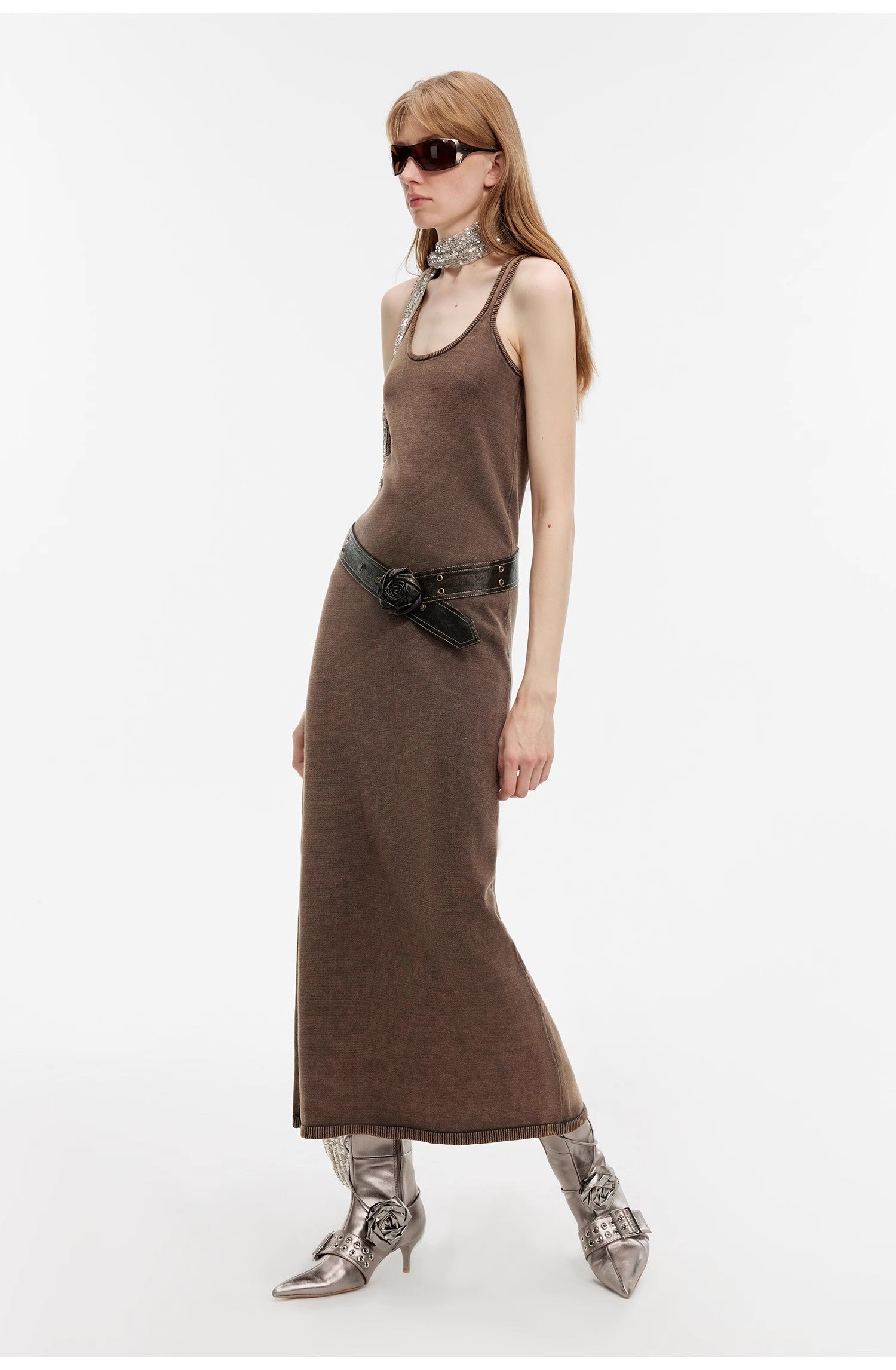 Model wearing Feryn Enzyme‑Washed Vest Dress with U-neckline, curved back, and soft distressed texture in brown, styled with belt and boots.