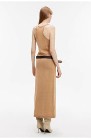 Back view of model wearing Feryn Enzyme-Washed Vest Dress in combed cotton, highlighting curved back and ergonomic side bindings.