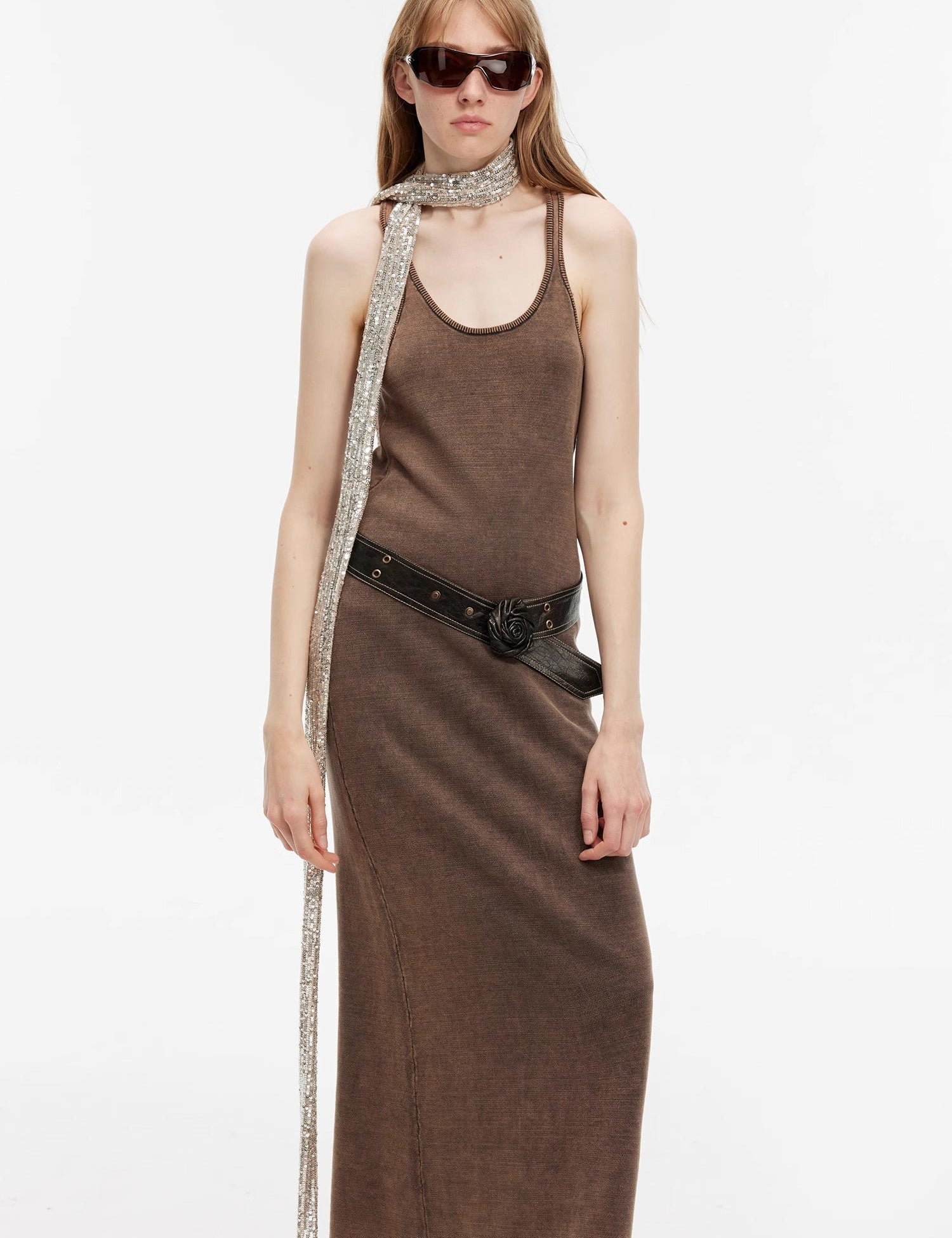 Model wearing Feryn Enzyme-Washed Vest Dress in brown with U-neckline and ergonomic side bindings, styled with a belt and scarf. 100% cotton.