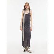 Woman wearing Feryn Enzyme-Washed Vest Dress in dark cotton with metallic scarf, highlighting U-neck and ergonomic side bindings.