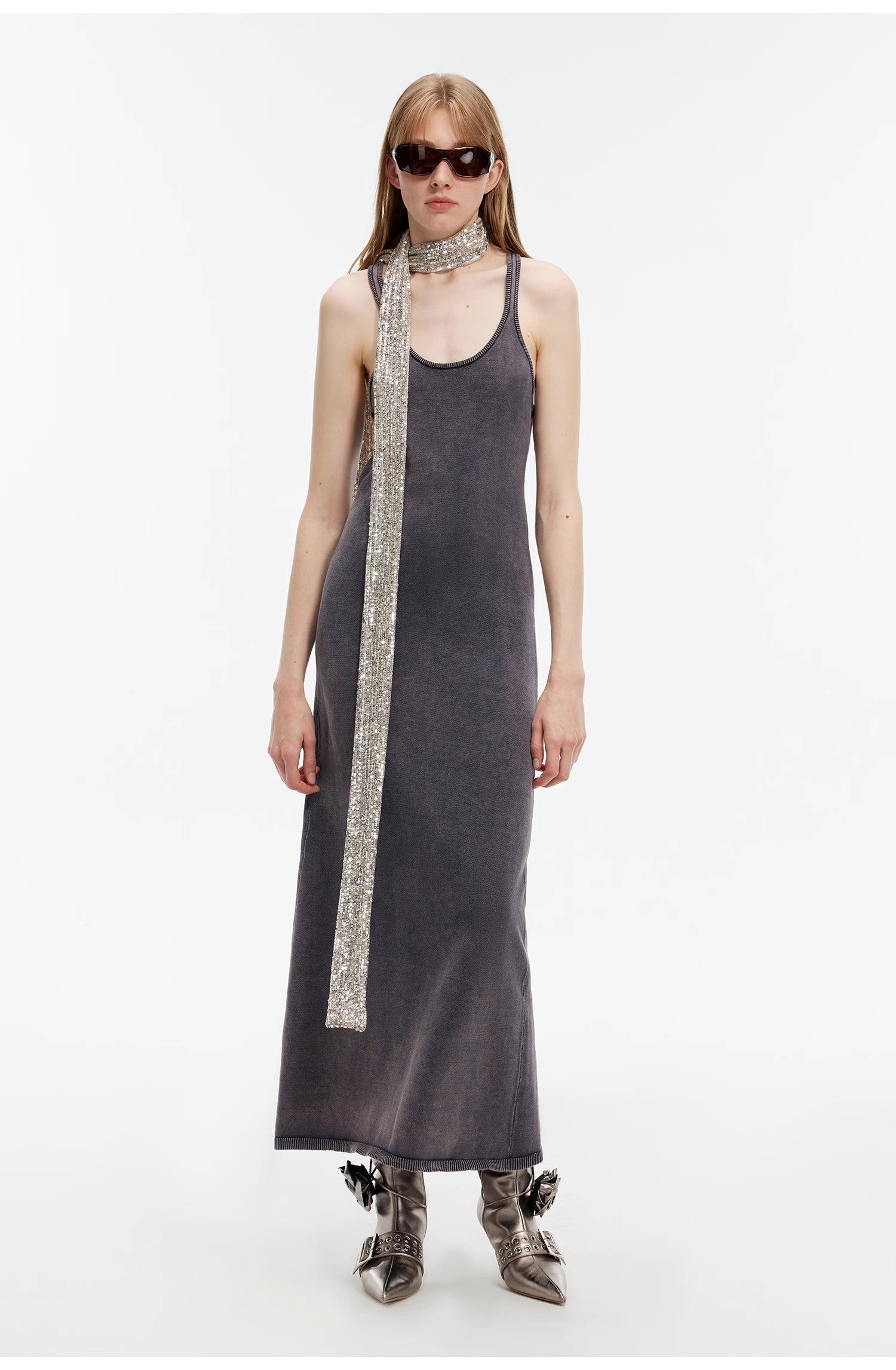 Model wearing Feryn Enzyme-Washed Vest Dress with U-neckline and curved back in dark, muted cotton, accessorized with scarf and sunglasses.