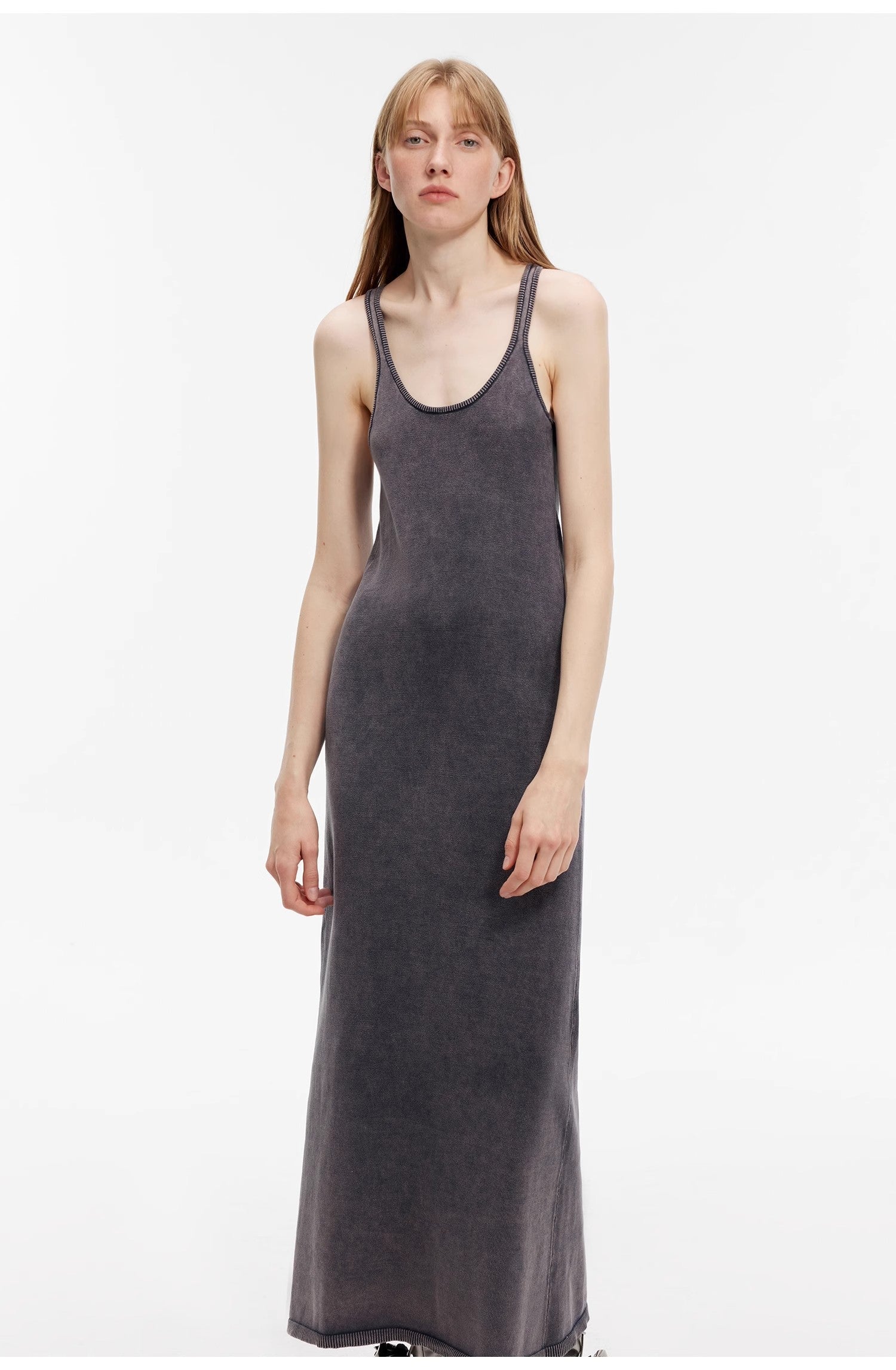 Woman wearing Feryn Enzyme-Washed Vest Dress with U-neckline and distressed look. Crafted from 100% combed cotton for softness.