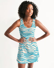 Woman wearing Coastline Drift Racerback Dress with blue wave pattern, showcasing its scoop neckline and sporty racerback style.