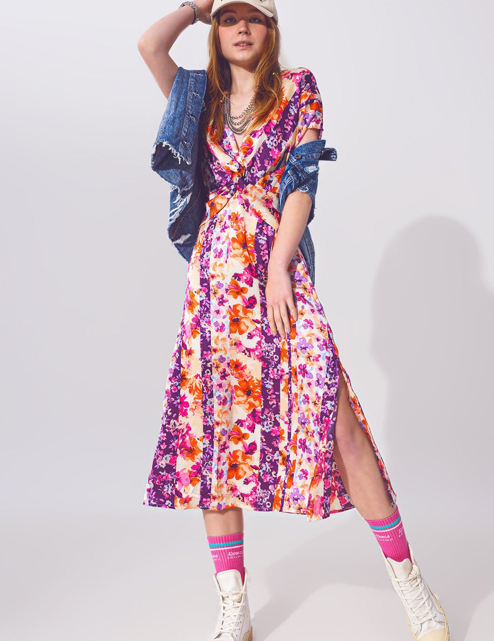 Florentia Knot-Front Midi Dress with floral print, modeled with denim jacket and sneakers, showcasing vibrant style and feminine charm.