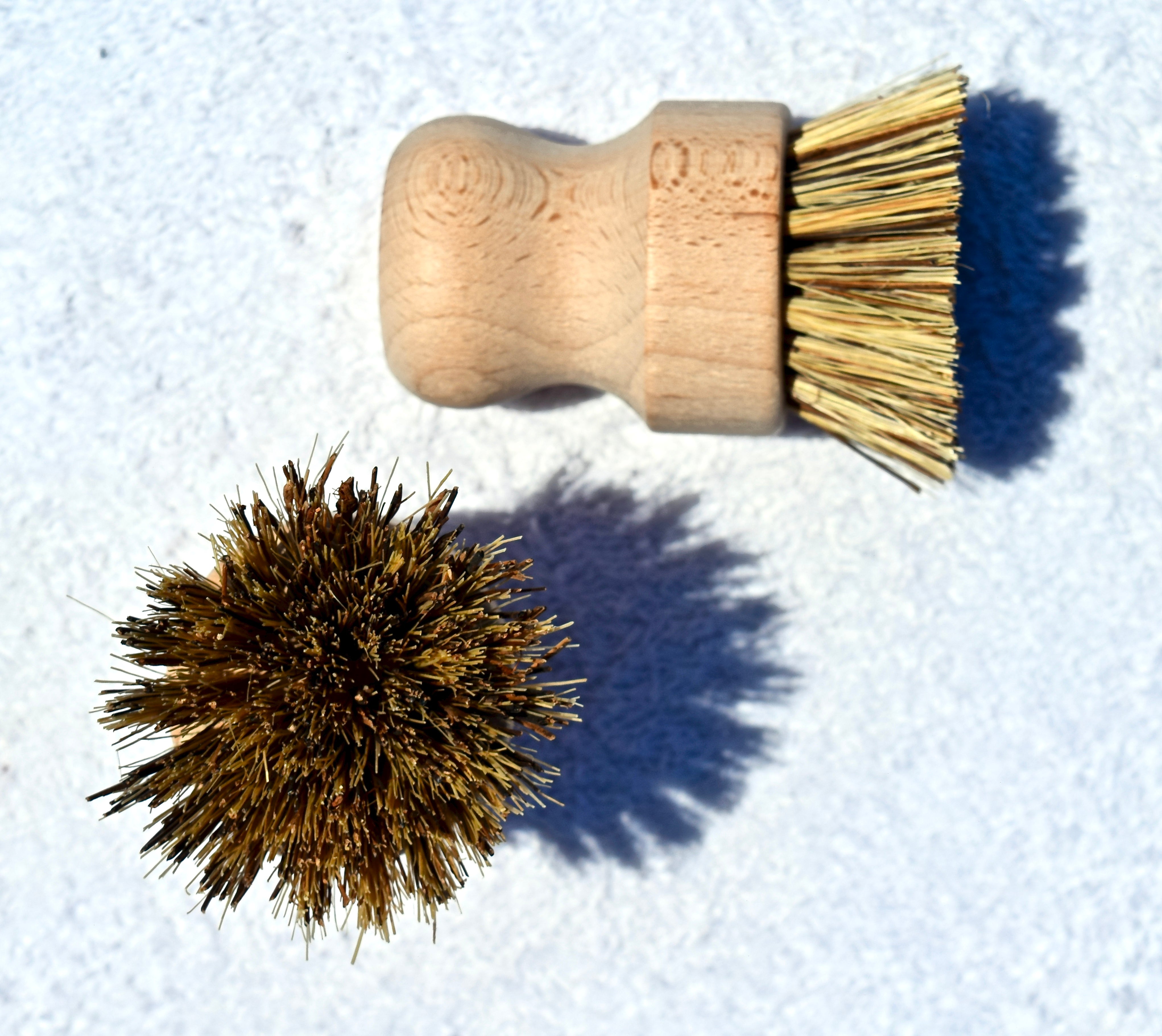 Biodegradable bamboo sisal cleaning brush with ergonomic wooden handle on a white background.