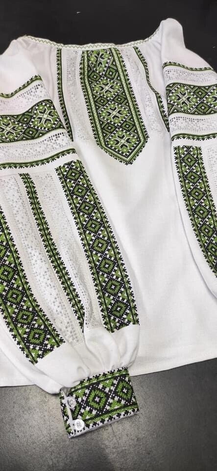 Women's Ukrainian embroidered blouse with green cross-stitch designs, made from natural cotton fabric, showcasing traditional patterns.