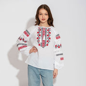 Girls' white vyshyvanka blouse with red and black floral embroidery, crafted from cotton linen, featuring lace and pom-pom details.