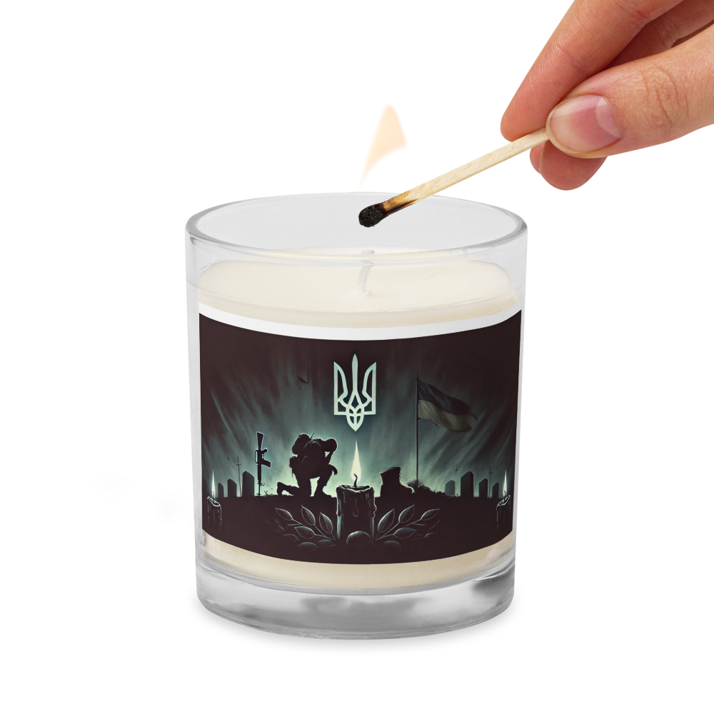 Hand-lighting soy wax candle with Ukrainian memorial design in glass jar, symbolizing remembrance and patriotism.