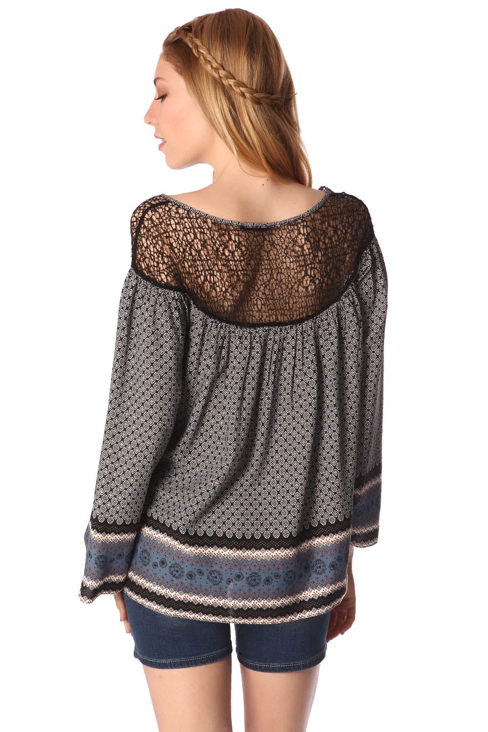 Woman wearing Elvarae Paisley Cage Blouse with gray paisley print and open cage neckline, showing back detail.