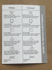 Guide to textile care symbols for white and colored fabrics detailing washing, drying, and ironing instructions.