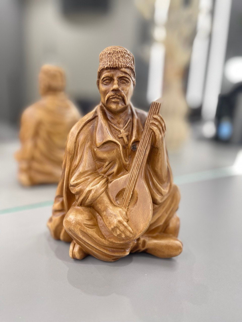 Hand-carved wooden bandurist figurine depicting Ukrainian musician with bandura, made from linden wood.