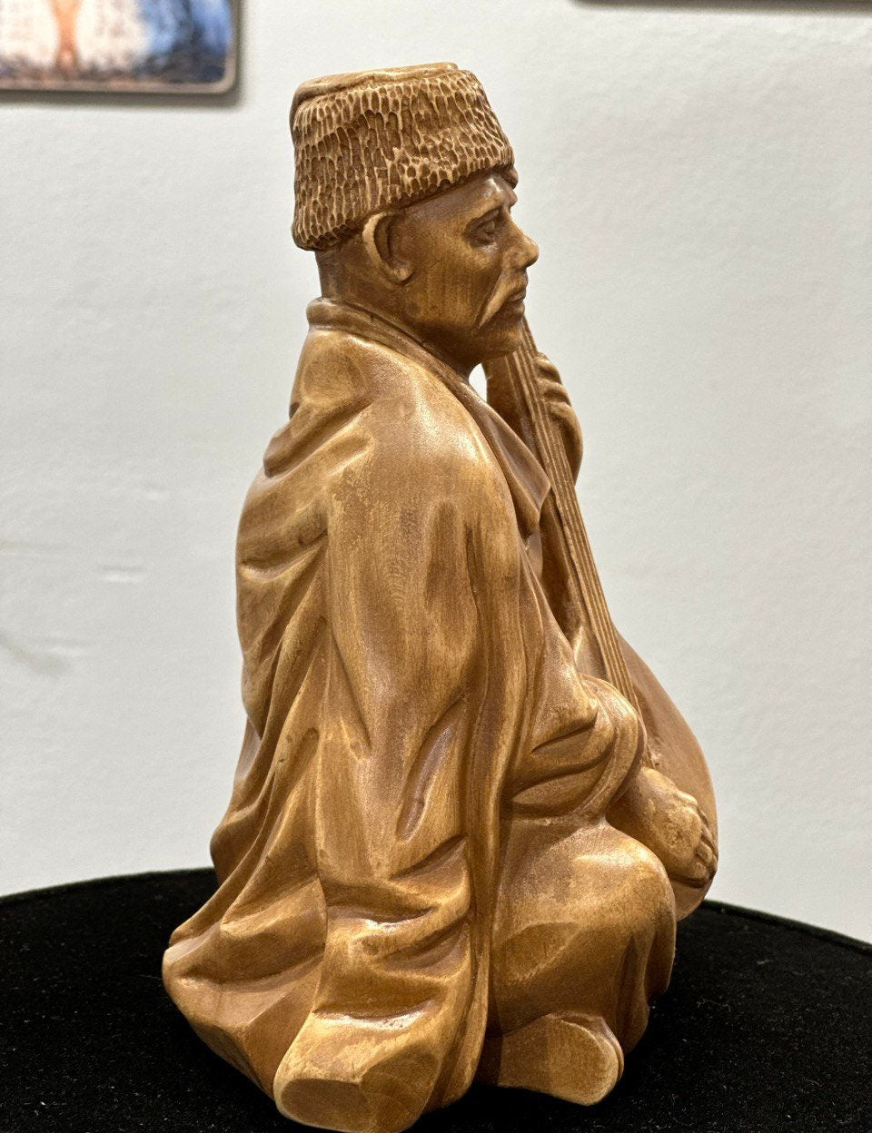Hand-carved wooden bandurist figurine made from linden wood, depicting a Ukrainian musician playing the bandura, symbolizing heritage.
