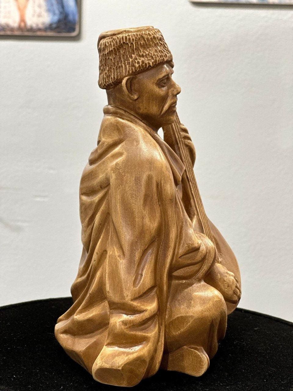 Hand-carved wooden bandurist figurine made from linden wood, depicting a Ukrainian musician playing the bandura, symbolizing heritage.