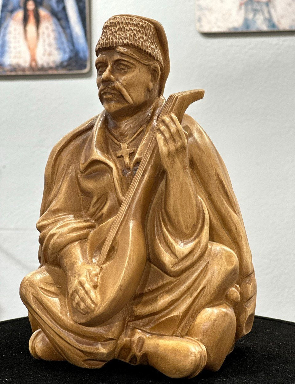 Hand-carved Ukrainian bandurist figurine made from linden wood, depicting traditional musician playing a bandura.