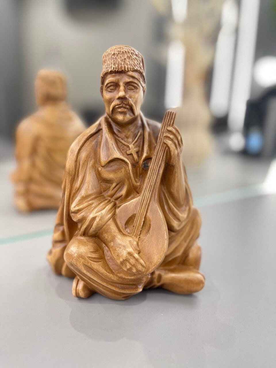 Hand-carved wooden bandurist figurine made from linden wood, showcasing traditional Ukrainian craftsmanship and culture.
