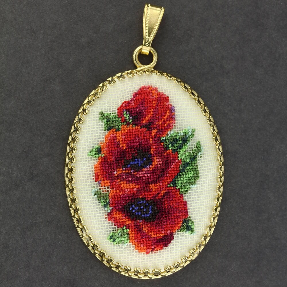 Hand-embroidered floral pendant necklace with Petit Point silk embroidery on gold frame, showcasing intricate red and green design.