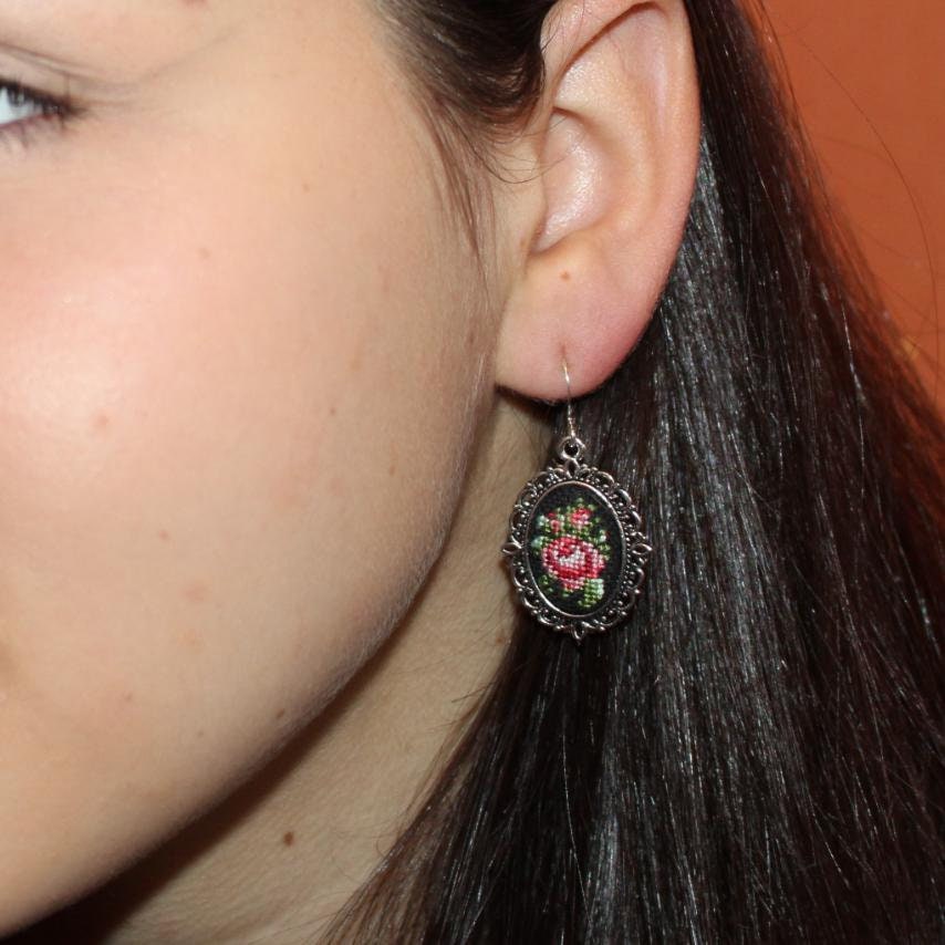 Woman wearing hand-embroidered petit point silk earring with floral bouquet design