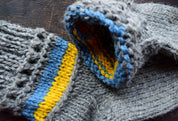 Hand-knitted grey woolen socks with Ukrainian flag colors, featuring blue and yellow accents, made from 100% natural wool.