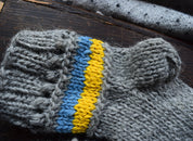 Hand-knitted grey woolen sock with blue and yellow stripes, showcasing Ukrainian flag colors, made from 100% natural wool.