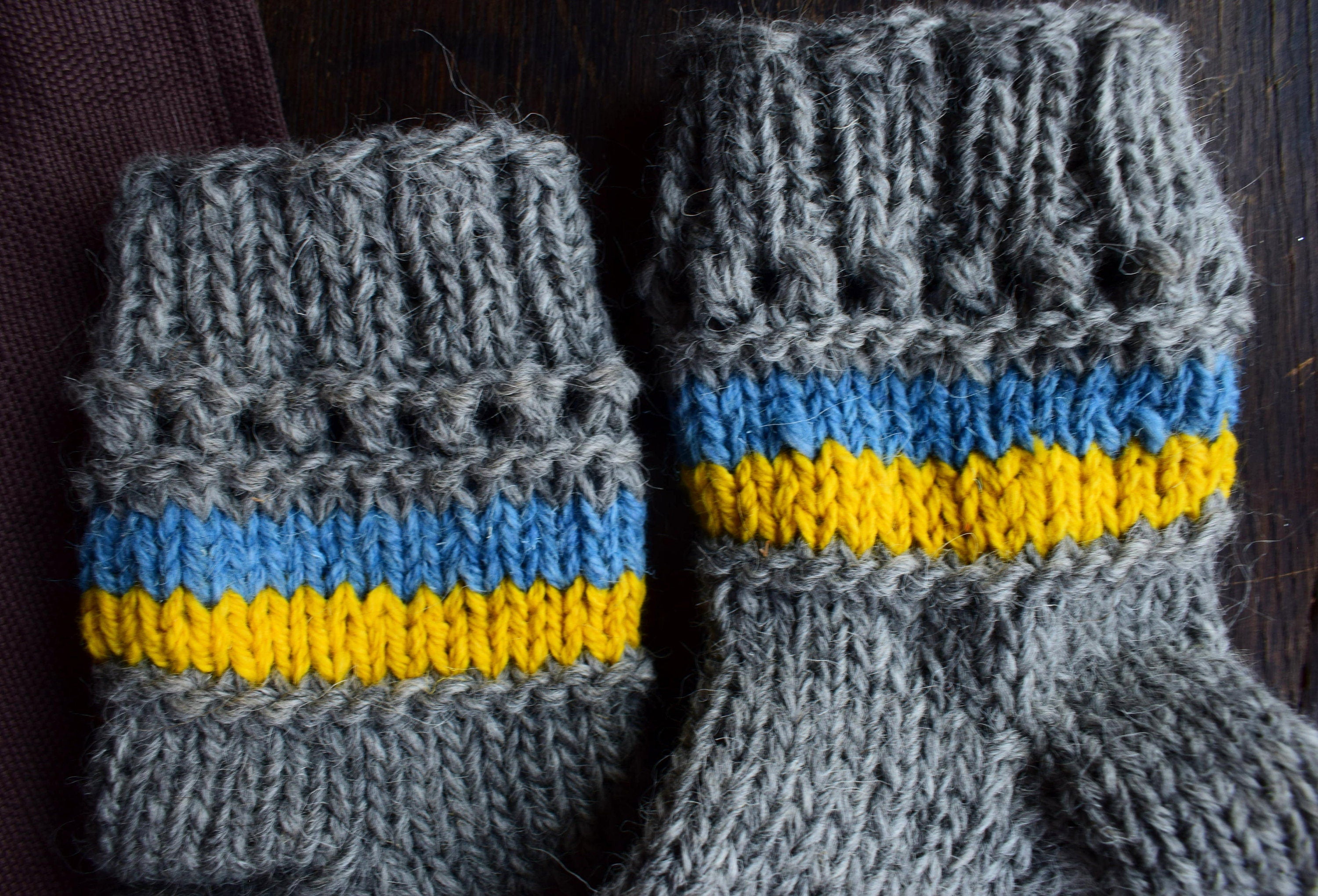 Hand-knitted grey woolen socks with Ukrainian flag colors, 100% natural wool, featuring blue and yellow stripes, cozy winter wear.