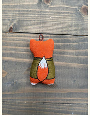 Hand-painted fox keychain in scout uniform, made from eco-friendly vanilla plast, ideal souvenir or decor, wooden background.