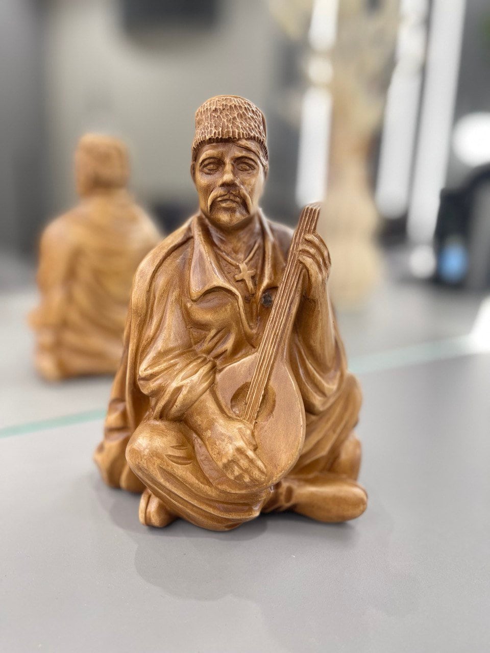 Hand-carved wooden bandurist figurine depicting a musician playing a bandura, made from natural linden wood, symbolizing Ukrainian culture.