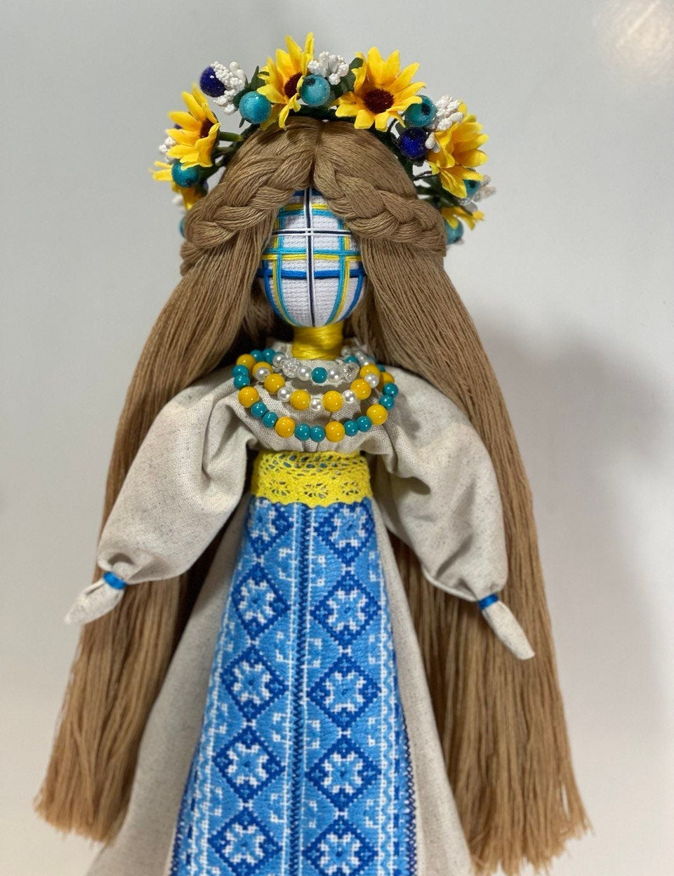 Handcrafted Ukrainian Motanka doll with embroidery, adorned with a sunflower crown, symbolizing resilience and spiritual guardianship.