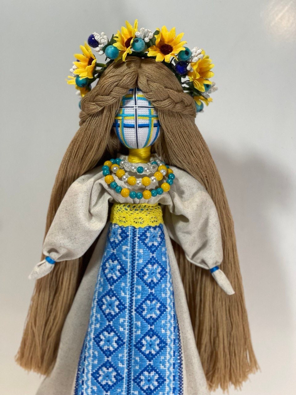 Handcrafted Ukrainian Motanka doll with embroidery, adorned with a sunflower crown, symbolizing resilience and spiritual guardianship.