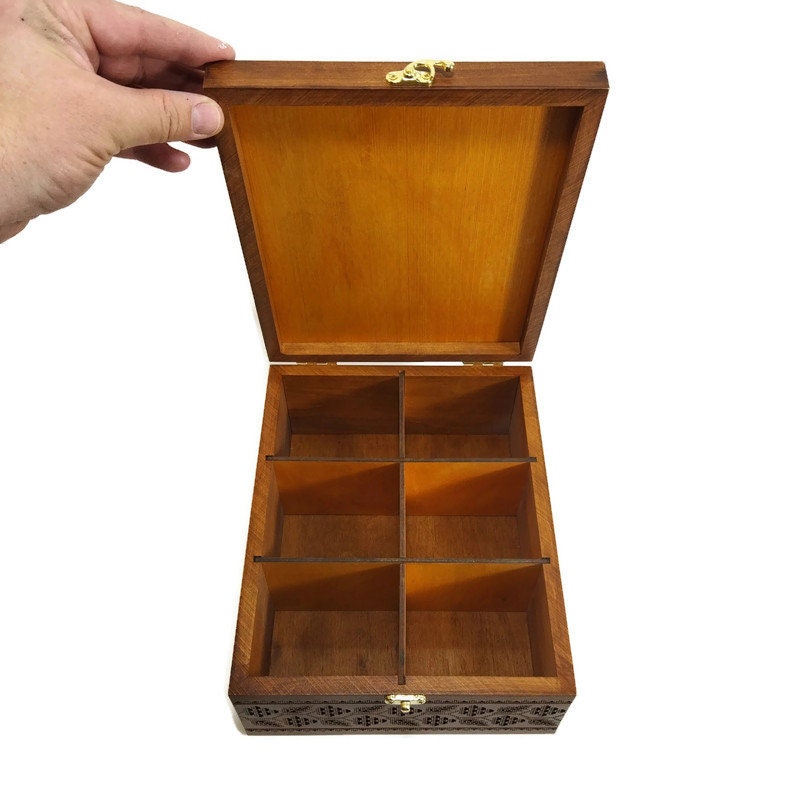 Handcrafted wooden tea box with embroidery-style engraving, showcasing six compartments and elegant Ukrainian trident design.