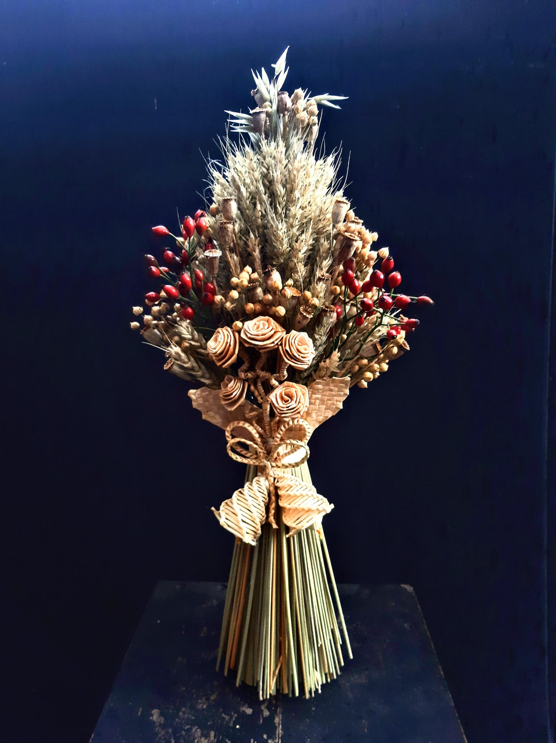 Handcrafted Ukrainian Didukh Christmas decoration with wheat sheaf and dried flowers, symbolizing tradition and prosperity.