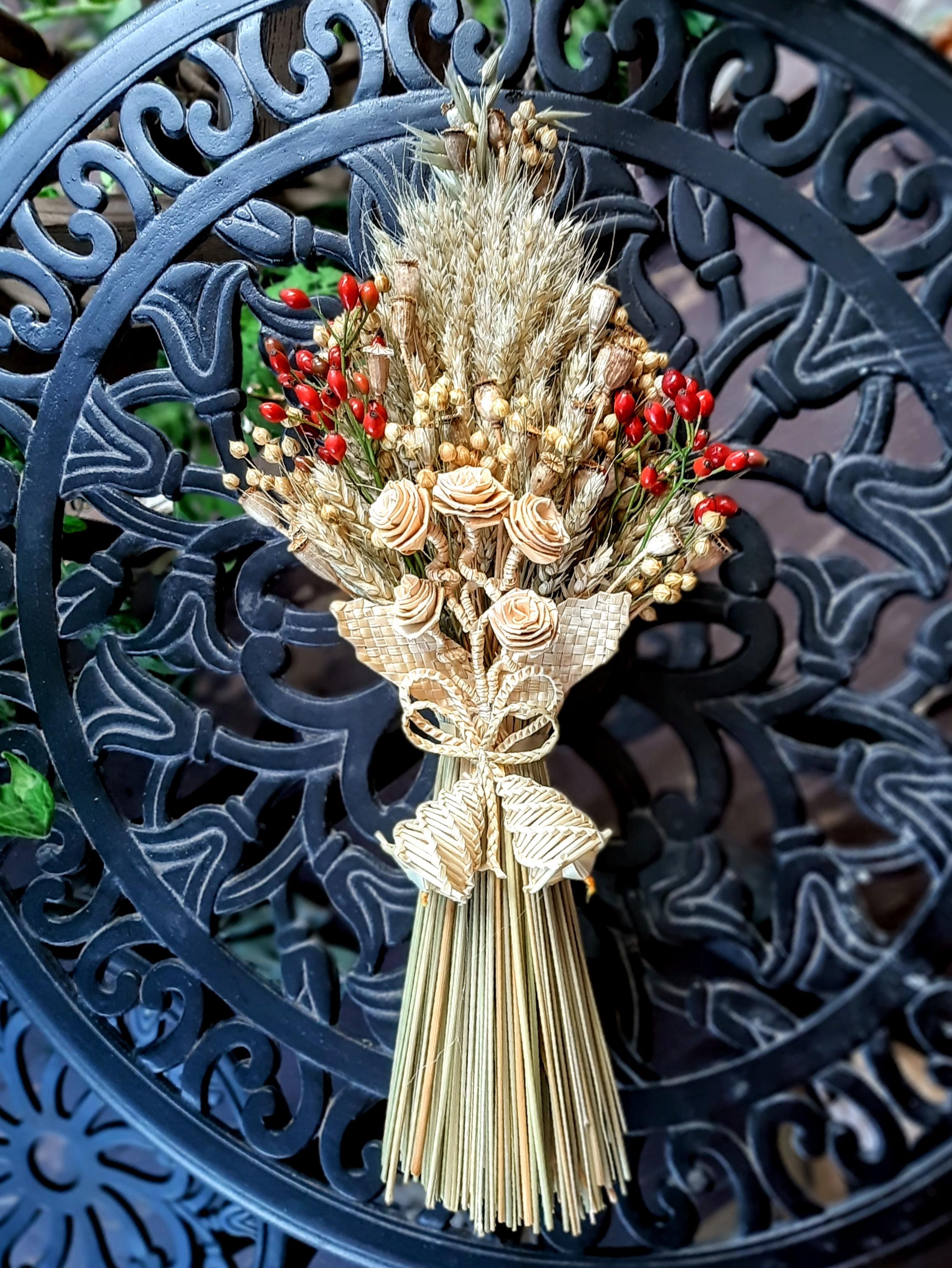 Handcrafted Ukrainian Didukh Christmas decoration made of wheat sheaf and dried flowers, symbolizing tradition and prosperity.