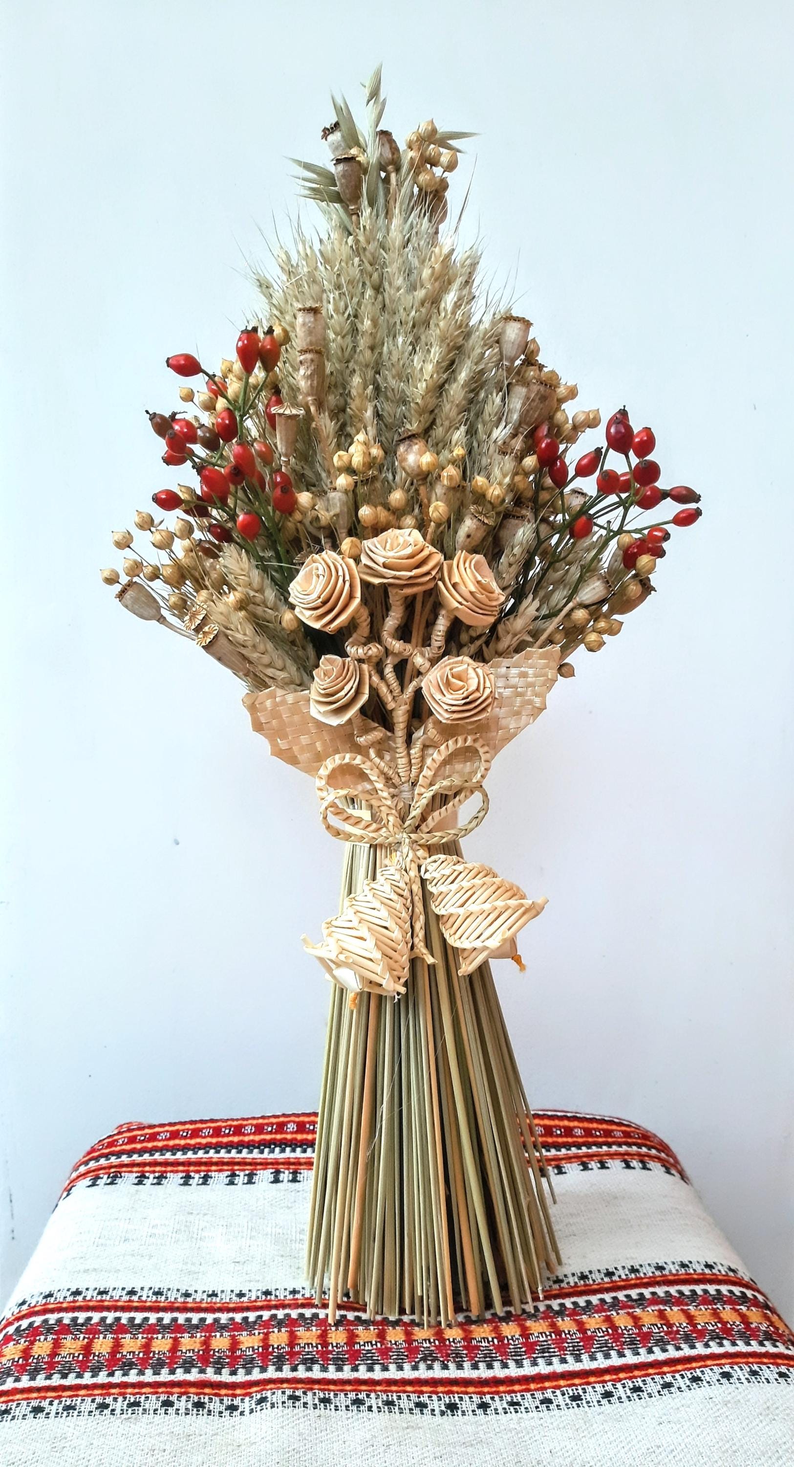 Handcrafted Ukrainian Didukh Christmas decoration with wheat sheaf and dried flowers, symbolizing tradition and prosperity.