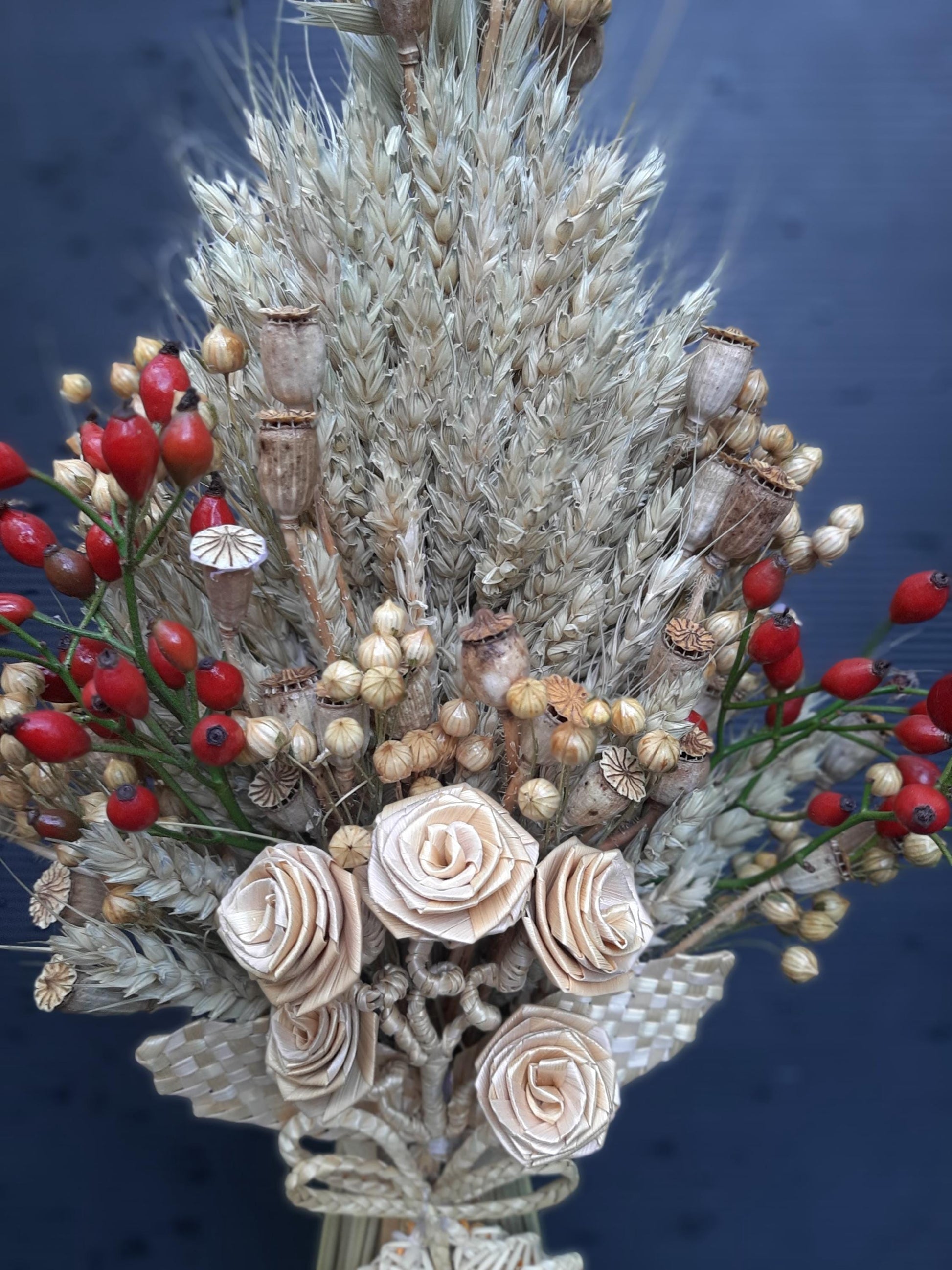Handcrafted Ukrainian Didukh Christmas decoration with wheat sheaf and dried flowers, symbolizing fertility and prosperity.