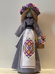 Handmade Bereginya Motanka Doll with embroidered apron and floral wreath, standing on wooden base, symbolizing Ukrainian protection.