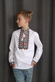 Boy wearing traditional Ukrainian embroidered vyshyvanka with cross-stitch on collar and cuffs.