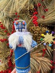 Handmade Motanka Doll “Christmas” on Wooden Stand with Embroidered Details, Surrounded by Festive Decorations
